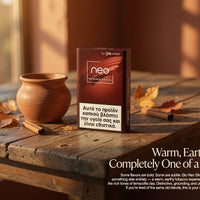 A pack of Neo Terra Nicotine Tobacco (Glo Neo Slimm) stands on a rustic wooden table next to a clay pot and autumn leaves, with a warm, sunlit background. Text overlays describe the product's warm, earthy flavor profile.